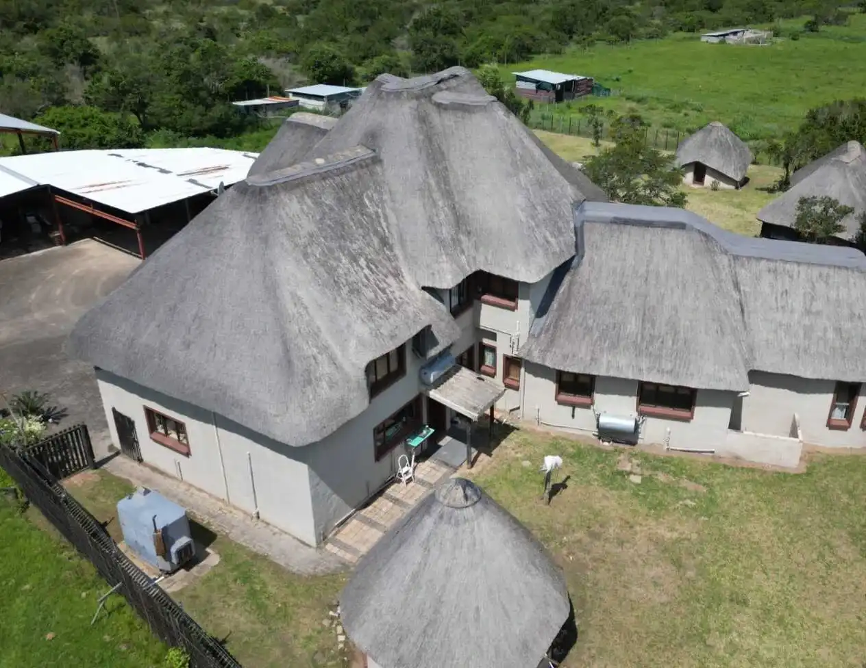 Aerial view of a thatched property with thatched gazebos